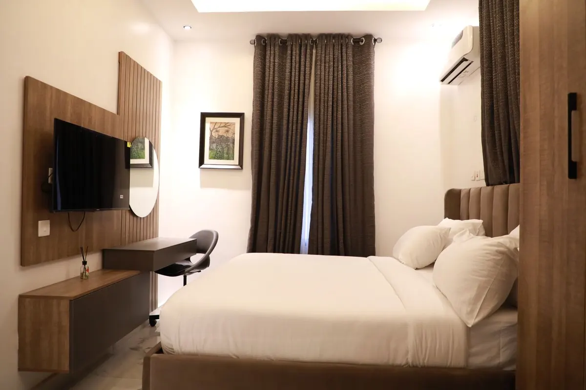 Inspirasi interior kamar hotel dengan tempat tidur dan aksen kayu